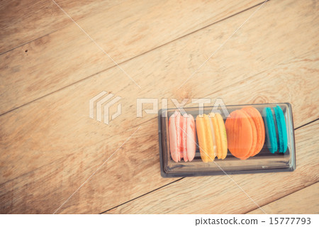 Colorful macaron in plastic box on wooden floor Colorful macaron in plastic box on wooden floor 15777793