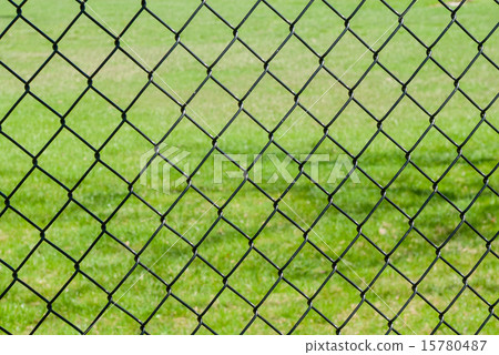 Chain link fence against grass 15780487