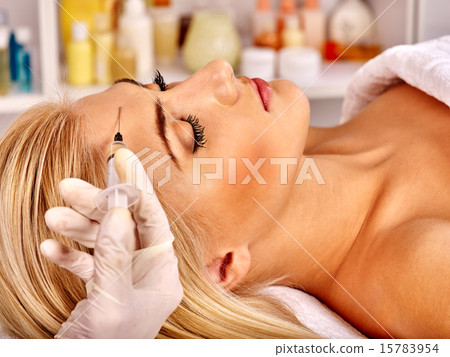 Woman giving botox injections. 15783954
