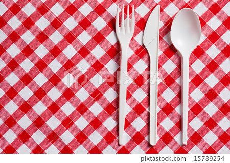 plastic cutlery on checkered tablecloth 15789254
