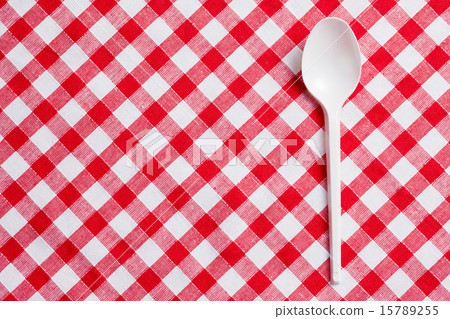 plastic spoon on checkered tablecloth 15789255