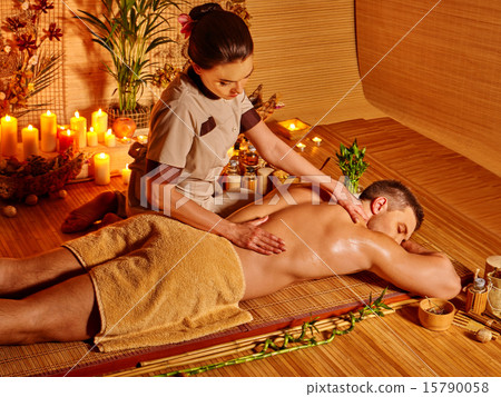 Man getting herbal ball massage treatments . 15790058