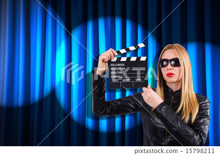 Girl with movie board against curtains Girl with movie board against curtains 15798211