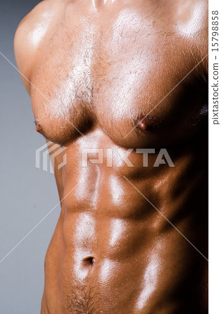 Muscular man in dark studio 15798858