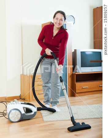 Happy mature woman with vacuum cleaner Happy mature woman with vacuum cleaner 15809257