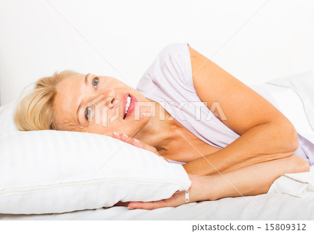 middle-aged woman waking on bed 15809312