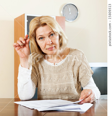 mature woman filling in paper 15809313