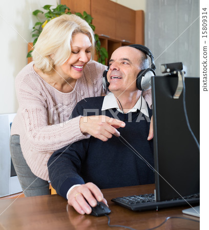 Senior couple using PC at home 15809314
