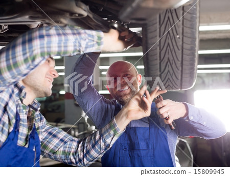 Smiling men in coveralls working 15809945