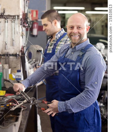 Smiling men in coveralls working 15810013