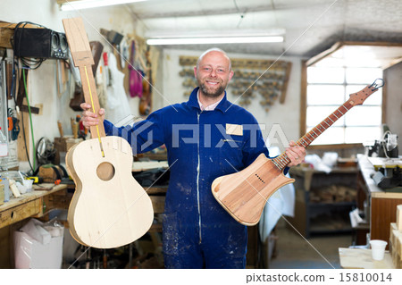 craftsman working with unfinished guitar 15810014