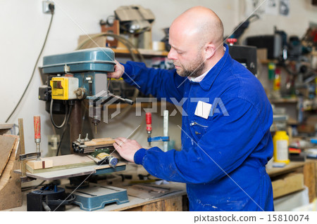 Woodworker on lathe in workroom Woodworker on lathe in workroom 15810074