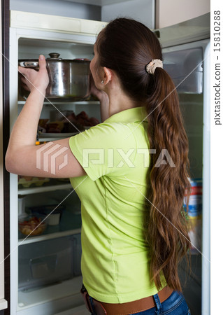 Girl standing near fridge 15810288