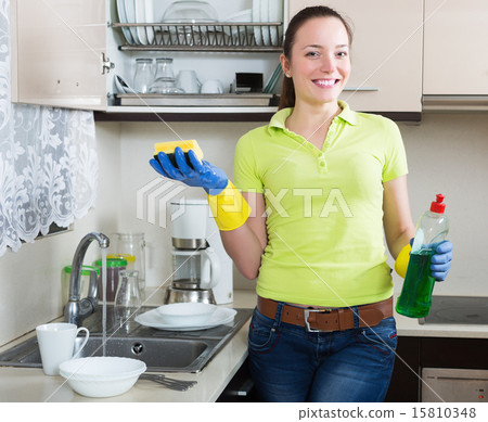Positive young housewife washing dishes Positive young housewife washing dishes 15810348
