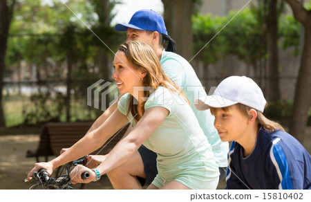 Family on bicycles in the park 15810402