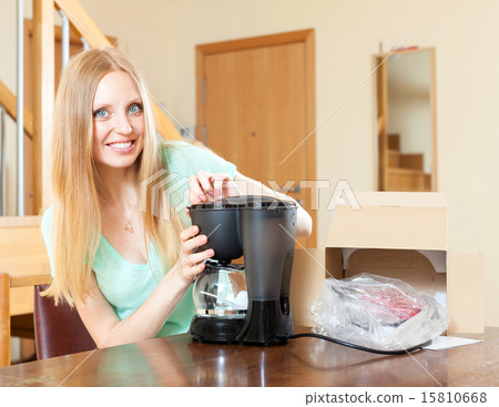 Happy young woman with new coffee machine at home Happy young woman with new coffee machine at home 15810668
