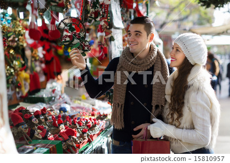 Happy couple choosing Christmas souvenirs Happy couple choosing Christmas souvenirs 15810957