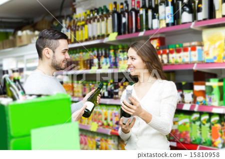 shoppers choosing bottle of wine at liquor store shoppers choosing bottle of wine at liquor store 15810958