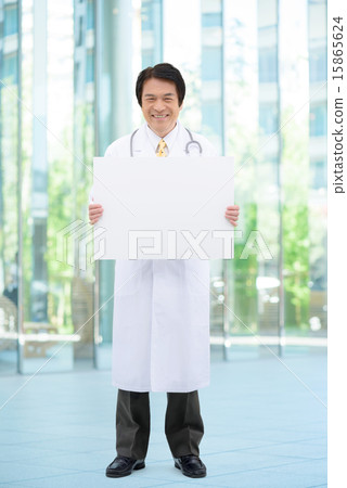 Full-body image of middle-aged male doctor standing at entrance of general hospital Full-body image of middle-aged male doctor standing at entrance of general hospital 15865624