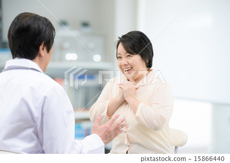 A middle-aged woman receiving a doctor's interview A middle-aged woman receiving a doctor's interview 15866440