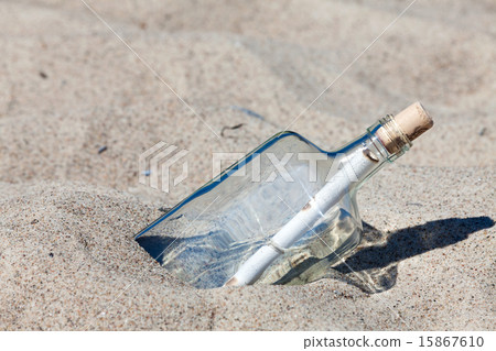 Message in a bottle stuck in sand on the beach Message in a bottle stuck in sand on the beach 15867610