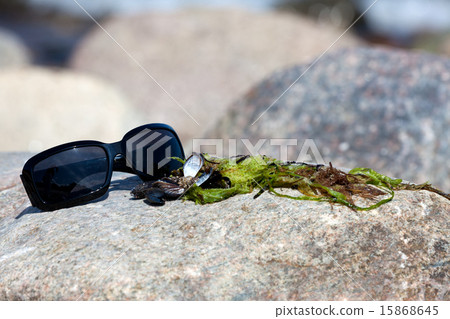 Sunglasses lies on a rock on the coast Sunglasses lies on a rock on the coast 15868645