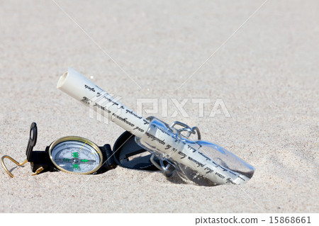 Message in a bottle with a compass is in the sand 15868661