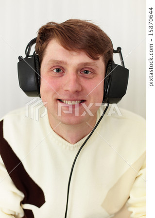 Cheerful guy with big ear-phones on a head Cheerful guy with big ear-phones on a head 15870644