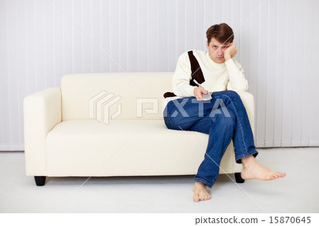 Young man misses sitting on sofa at the TV Young man misses sitting on sofa at the TV 15870645