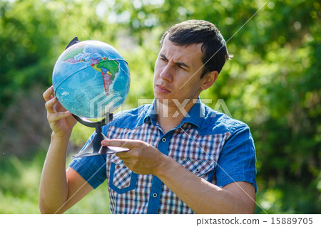 man in the street holding a globe on green background summer lea 15889705