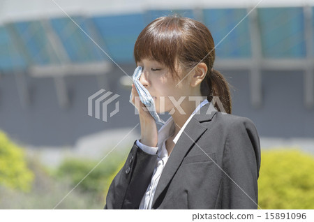 A young woman in suit wearing a hot summer wiping sweat A young woman in suit wearing a hot summer wiping sweat 15891096