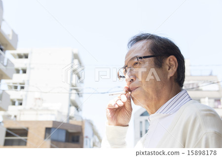 A smoker senior man smoking a cigarette on the balcony 15898178