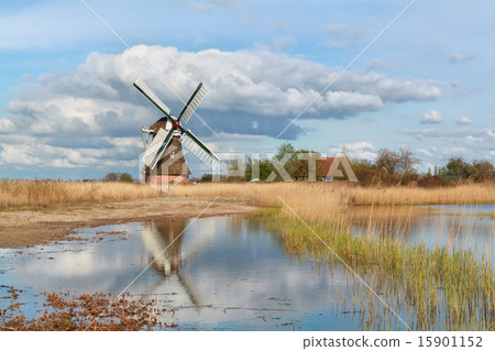 Dutch windmill by river and blue sky 15901152