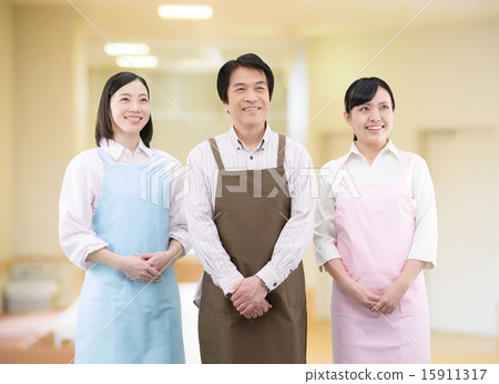 一個小組的圖像三個男人和婦女圍裙的在屋子裡 15911317