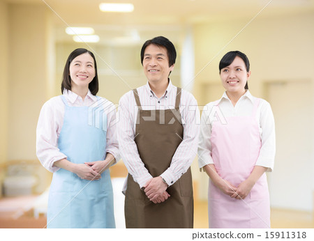 一個小組的圖像三個男人和婦女圍裙的在屋子裡 15911318