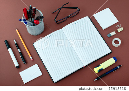 Office Supplies Arranged Around Notebook on Desk 15918518