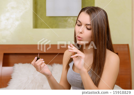 Young woman drying her fresh made nails 15918829