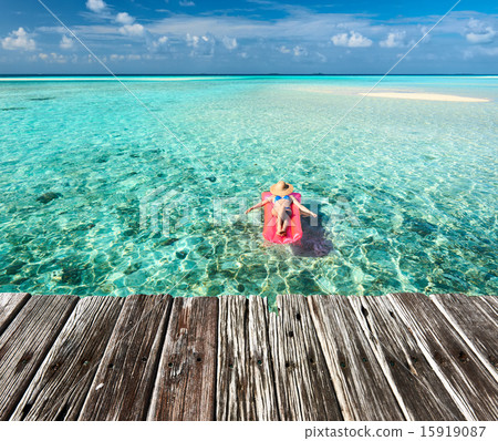 Woman relaxing on inflatable mattress Woman relaxing on inflatable mattress 15919087
