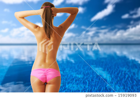 Woman topless at tropical swimming pool 15919093