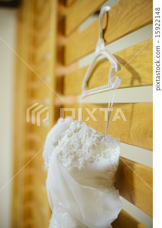 Wedding dress hanging against a wall 15922148