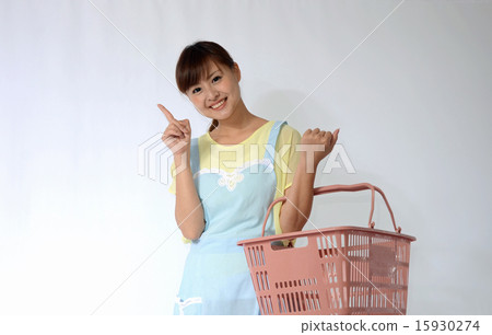 A young woman in an apron with a shopping basket 15930274