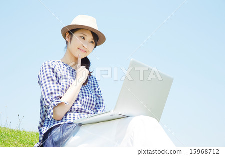 使用便攜式計算機的婦女外面 15968712