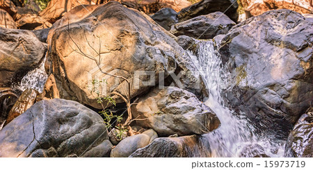 Small waterfall with trees and rocks in mountain 15973719
