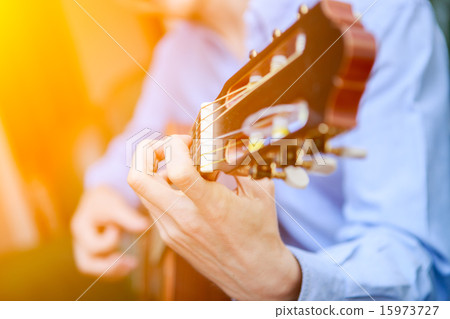 Young musician playing at acoustic guitar Young musician playing at acoustic guitar 15973727