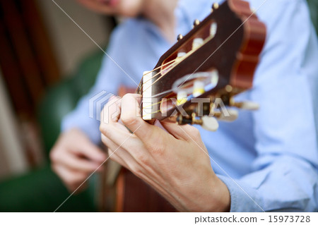 Young musician playing at acoustic guitar Young musician playing at acoustic guitar 15973728