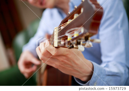 Young musician playing at acoustic guitar Young musician playing at acoustic guitar 15973729