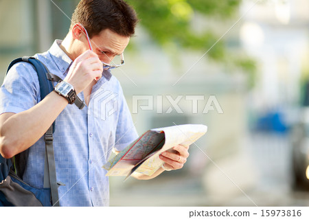 Young man with a map outdoors Young man with a map outdoors 15973816