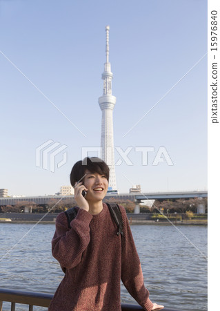 A young man speaking on a smartphone 15976840