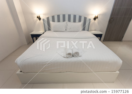 White bed with white cement wall and yellow light White bed with white cement wall and yellow light 15977126