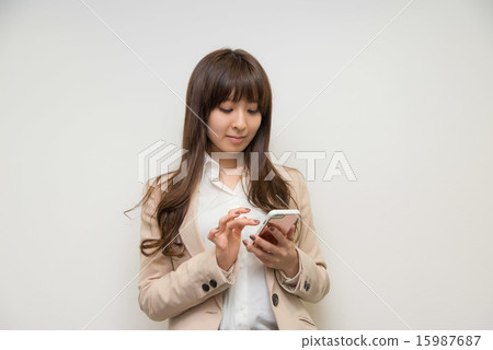 A young woman operating a phone A young woman operating a phone 15987687